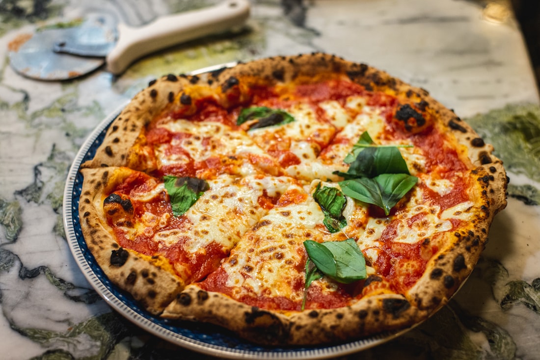 Neapolitanische Margherita mit luftigem, im Holzofen gebackenem Rand und frischem Basilikum